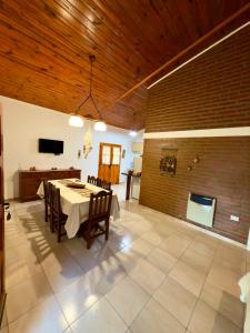 a dining room with a table and a brick wall at Complejo Entre Olmos in Santa Rosa de Calamuchita