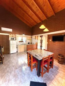 a large kitchen with a table and chairs and a kitchen with at Complejo Entre Olmos in Santa Rosa de Calamuchita