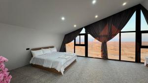 a bedroom with a bed and large windows at Moon Light Camp in Bidiyah