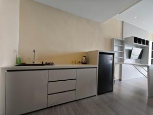 a kitchen with a sink and a refrigerator at Nagoya Thamrin Cozy Apartment 11TH City View in Nagoya +4 photos