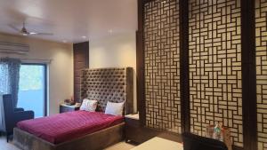 a bedroom with a bed and a large window at Nivasa Villa - 5 BHK Triplex House Near Cyberhub in Gurgaon