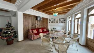 a living room with a christmas tree and a table and chairs at Mahbubakhon Guest house in old city in Bukhara