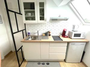 a small kitchen with a sink and a microwave at Hébergement Golfe du Morbihan - Ty Baden in Baden