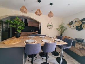 a dining room with a wooden table and chairs at L'Échappée Belle près de Toulouse in Castelnau-dʼEstrétefonds