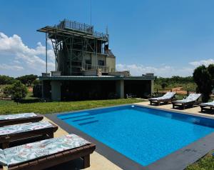 a swimming pool with two lounge chairs and a house at Rockey Mountain Tower in Bela-Bela