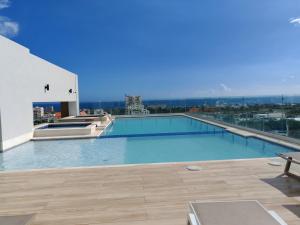 a large swimming pool on the roof of a building at Style and Confort Apart Villa Palmera in Santo Domingo