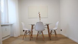 een eettafel met witte stoelen en een tafel bij Apartment auf Schalke in Gelsenkirchen +12 foto's