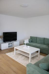 een woonkamer met een groene bank en een witte salontafel bij Apartment auf Schalke in Gelsenkirchen