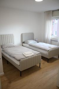 2 witte bedden in een kamer met een raam bij Apartment auf Schalke in Gelsenkirchen