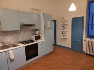 a kitchen with white cabinets and a stove top oven at Michelangelo's Relais in Florence