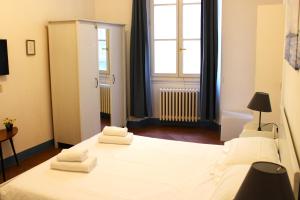 a bedroom with two beds with white sheets and a window at Michelangelo's Relais in Florence