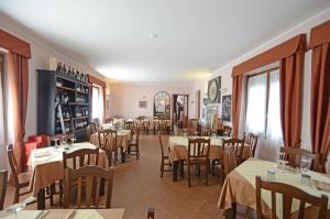 um restaurante com mesas e cadeiras num quarto em Relais Ristorante Sanfront em Ponzone