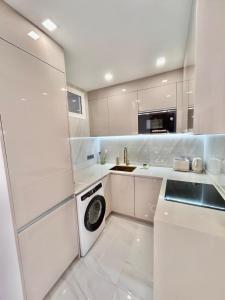 a white kitchen with a washing machine in it at Adeje Paradise in Adeje