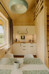 eine Küche mit einem Tisch, Stühlen und einer Leuchte in der Unterkunft Osada Chmiel in Chmielno + 72 Fotos