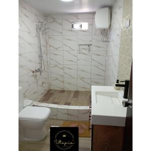 a bathroom with a toilet and a sink at Utopía Hogar in Balneario Argentino