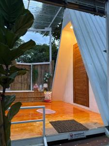 ein kleines Haus mit Holzboden und einer Tür in der Unterkunft Tid Khao Glamping & Bar in Tha Kradan