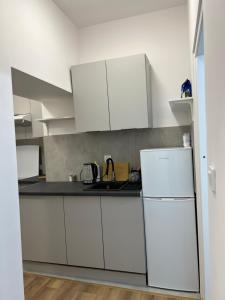 a kitchen with white cabinets and a white refrigerator at Nowe mieszkanie in Pabianice
