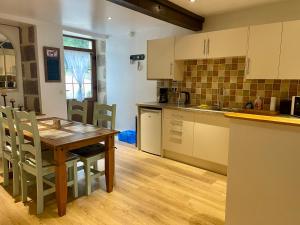a kitchen with a wooden table and a wooden floor at Tranquil Watermill in Pré-en-Pail