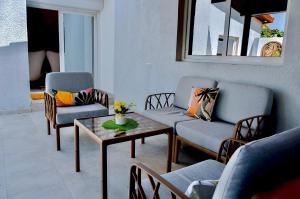 ein Wohnzimmer mit zwei Stühlen und einem Couchtisch in der Unterkunft La Villa Moringa, meublée et équipée in Saly Portudal