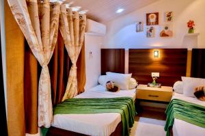 ein Hotelzimmer mit 2 Betten und Vorhängen in der Unterkunft La Villa Moringa, meublée et équipée in Saly Portudal + 85 Fotos