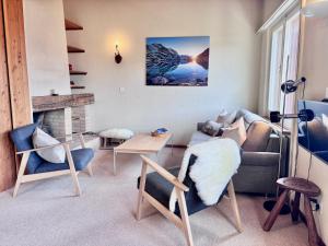 翁根Jungfraujoch, Chalet Ski In&Out, Wengen, Valley view的带沙发、椅子和壁炉的客厅
