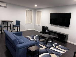 a living room with a blue couch and a flat screen tv at Lucy Private Studio in Providence