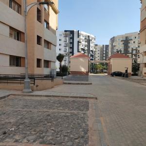 an empty street in a city with tall buildings at العاصمة الإدارية in Cairo