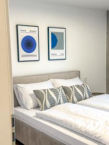 two beds in a bedroom with two pictures on the wall at Sunset Club - LOFT II - 160 m2 - Zentral in Memmingen