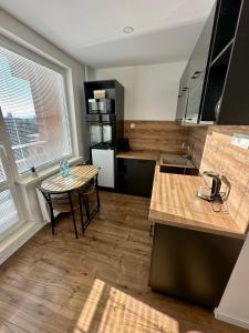 a kitchen with a table and a small table with a table at Apartmánový byt Bakossova in Banská Bystrica +17 photos