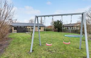 a swing set in a yard with a house at 2 Bedroom Stunning Home In Grenaa in Grenå