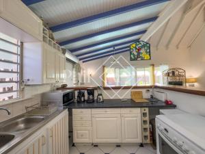 una cucina con armadi bianchi e soffitto blu di 3 bed-rooms Villa at Orient Beach a Orient Bay