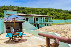 a house with a patio with a table and an umbrella at Tucanos Buzios in Búzios +26 photos