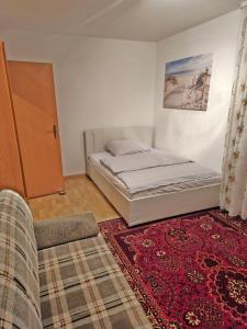 a bedroom with a bed and a couch and a rug at Alfeld City Apartment in Alfeld