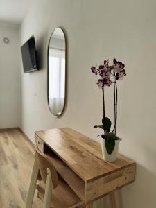 a wooden table with a vase with a flower on it at Riviera Smart Rooms in Fondi +22 photos