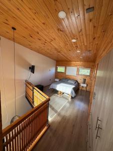 a bedroom with a bed and a wooden ceiling at Casa con acceso directo a playa en condominio in Pichilemu