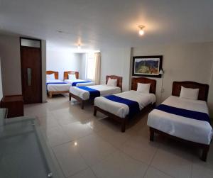 a hotel room with four beds and a tv at Hotel Sideral AQP in Arequipa +38 photos