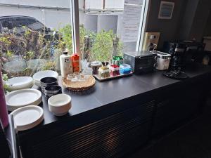 um balcão com pratos e chávenas e uma máquina de café em Mandalar Arch 39 Hotel em Chiang Mai