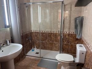 a bathroom with a shower and a toilet and a sink at Melo Home 1 Near Airport, Elevator in Vecindario +30 photos