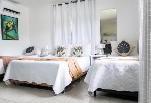 a bedroom with two beds and a mirror at Tucanos Buzios in Búzios