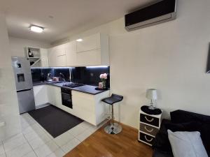 a kitchen with white cabinets and a black counter top at Apartman Tonka in Šibenik +6 photos