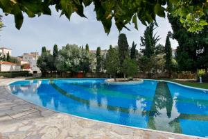 a blue swimming pool with trees in the background at Lovely & Stylish! 3BR Specious Penthouse-Serenity Skyview in Paphos