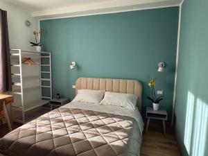 a bedroom with a large bed with a blue wall at Riviera Smart Rooms in Fondi