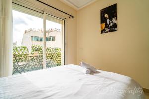 Un dormitorio con una cama blanca y una ventana grande. en Gauthier 5-Star Luxury Gem, en Casablanca