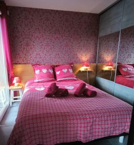 a bedroom with a pink bed with pink sheets at Charmant appartement in Saint-Gervais-les-Bains