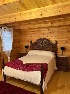a bedroom with a bed in a log cabin at Quinta do Pinheiro in Ourém