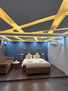 a bedroom with a bed and a couch and yellow ceilings at Farmhouse - A Luxury Living in Srinagar