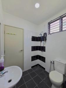 a bathroom with a white toilet and a sink at SD Home in Rawang in Batu Arang
