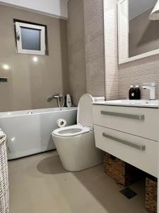 une salle de bain avec toilettes, baignoire et lavabo dans l'établissement One, à Craiova