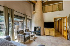Una sala de estar con un sofá y un televisor. en Casa rural Mas Plantalech, en Girona