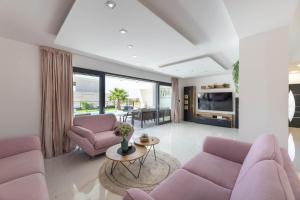 een woonkamer met paarse banken en een tafel bij Villa Golden Shine in Primošten